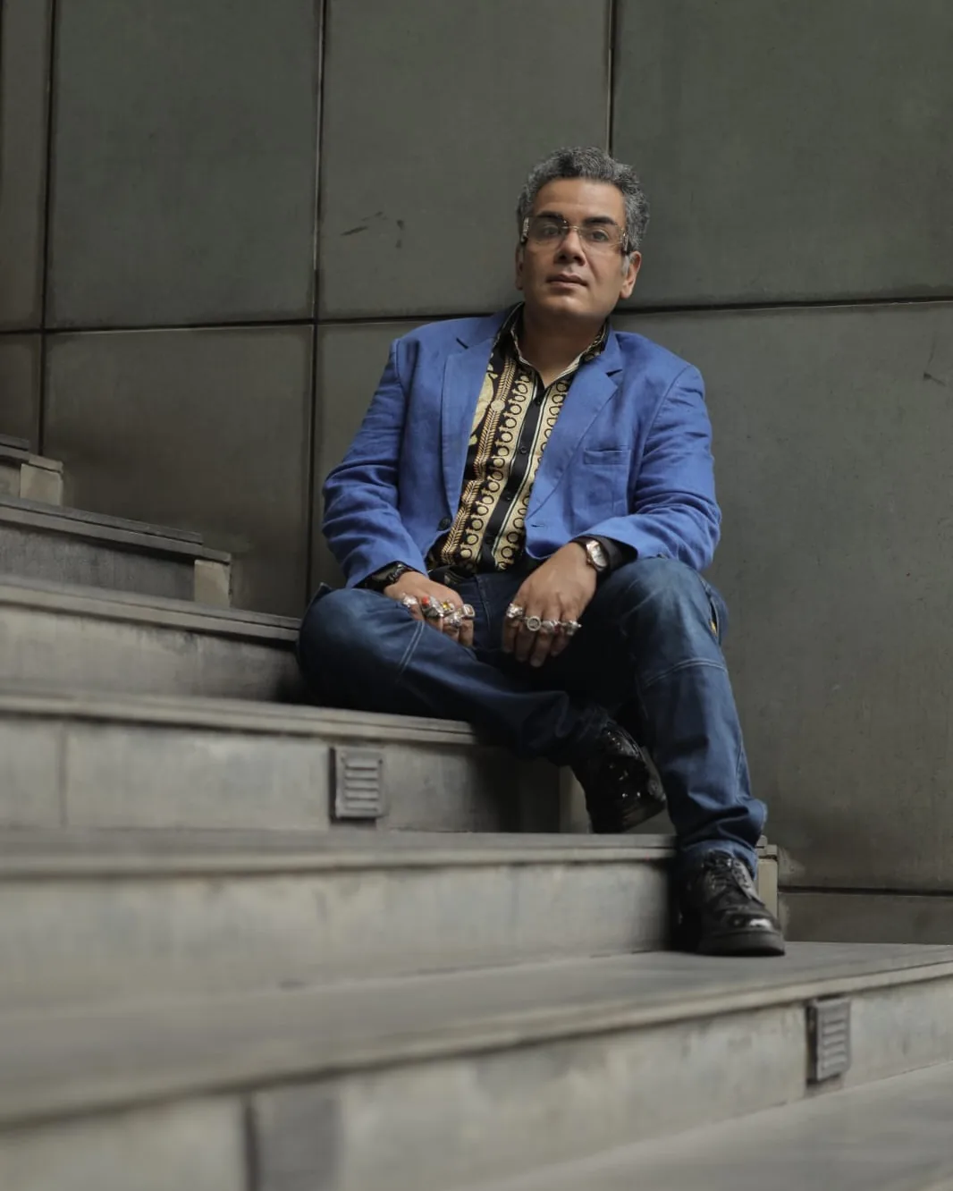 Sudeep Ranjan Sarkar seated on stone steps, hands resting together