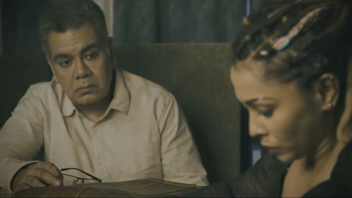 A man and a woman across a table in low light, a still from TEH, The Layer
