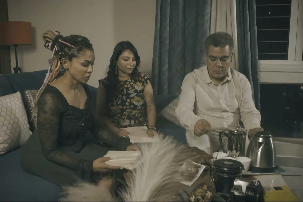 A group seated around a low table in a lit room, from TEH, The Layer