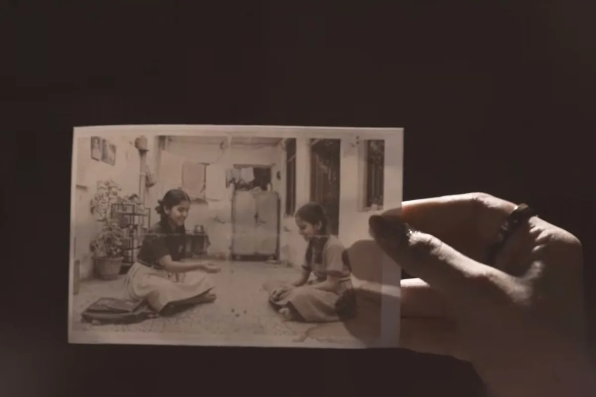 A hand holding an old photograph, from Ek Mausiqi ka Dabba