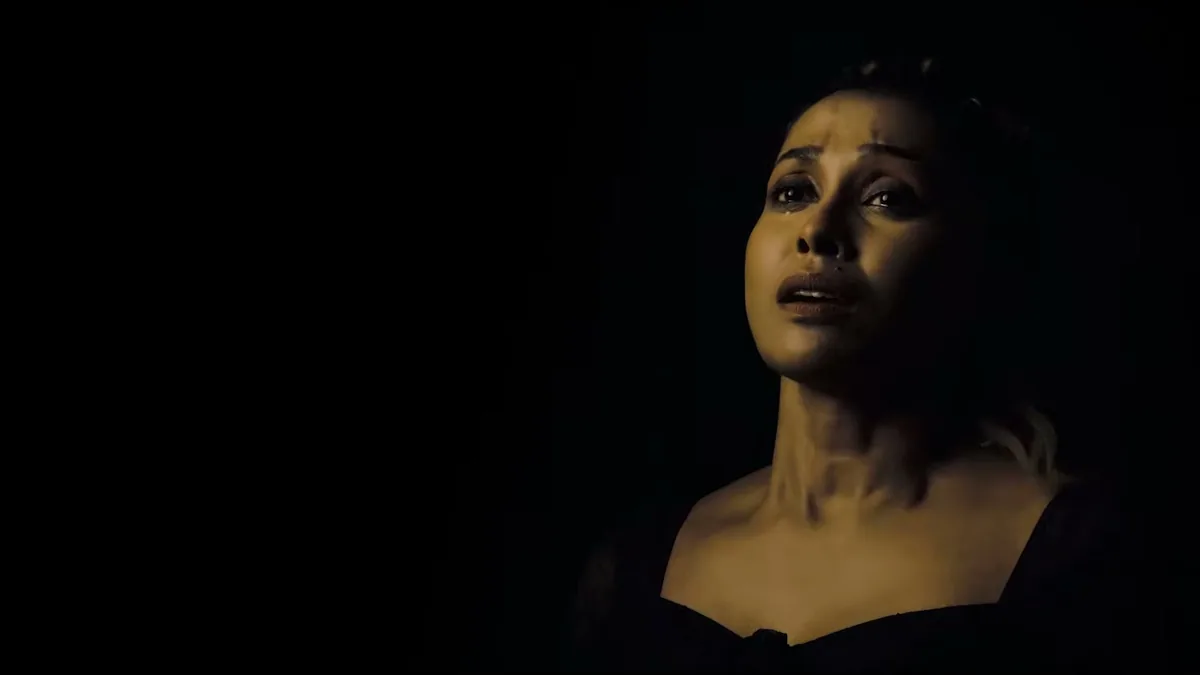 A woman lit against darkness, a still from TEH, The Layer