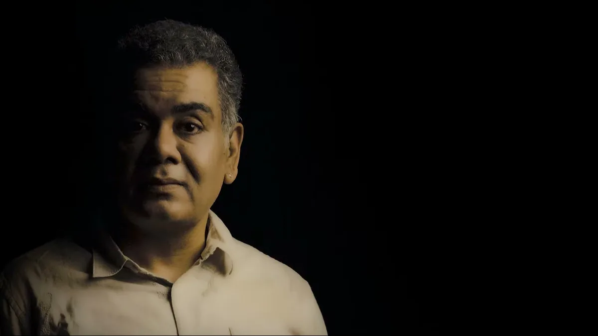 A man's face emerging from shadow, a still from TEH, The Layer