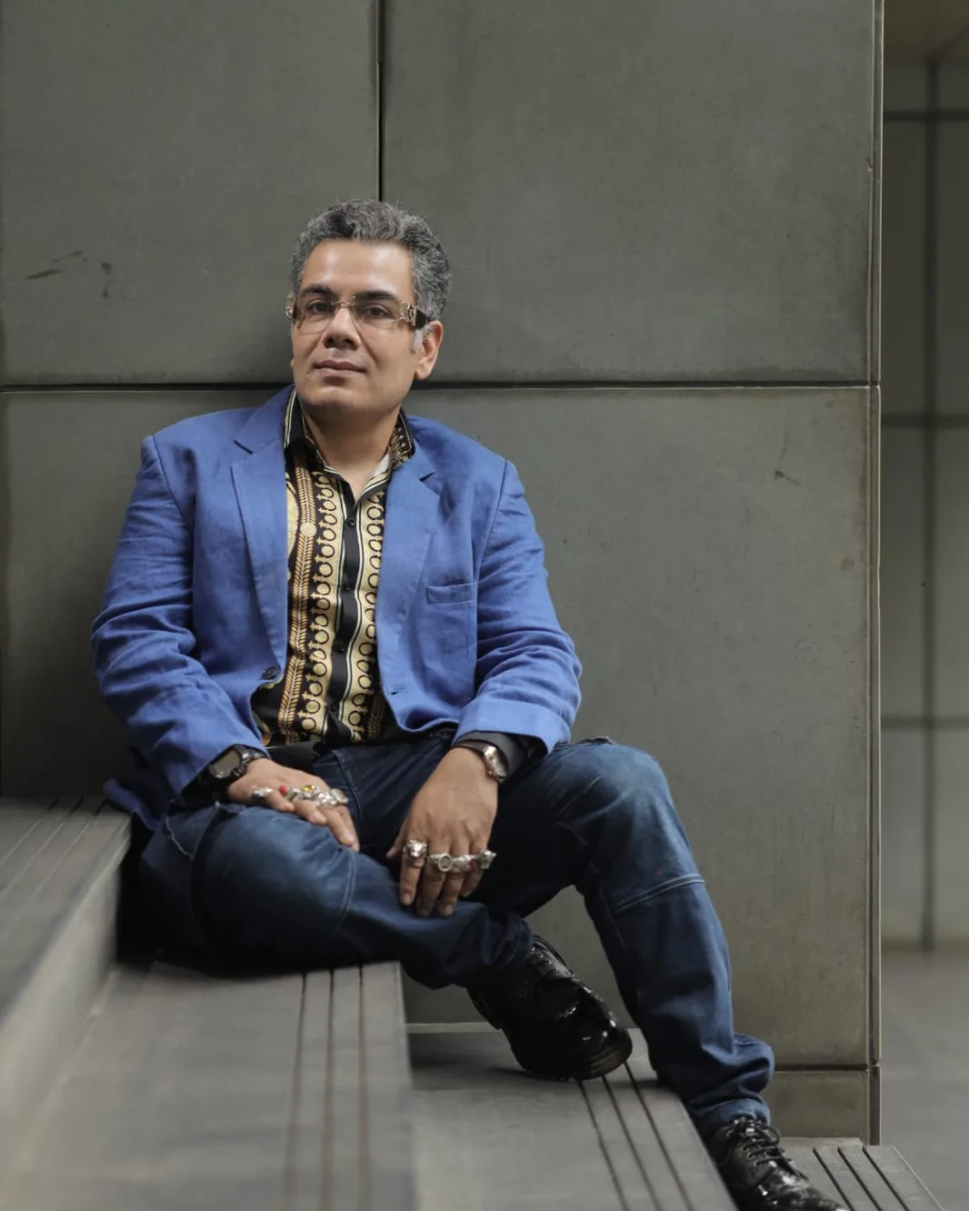 Sudeep Ranjan Sarkar seated on the ground against a concrete wall, looking into the camera