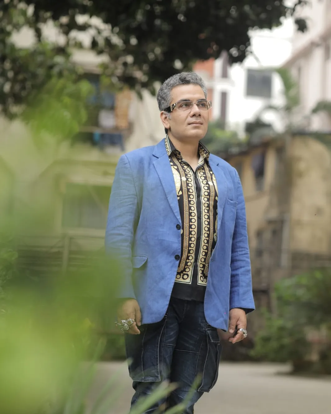 Sudeep Ranjan Sarkar walking through a Kolkata lane, greenery overhead