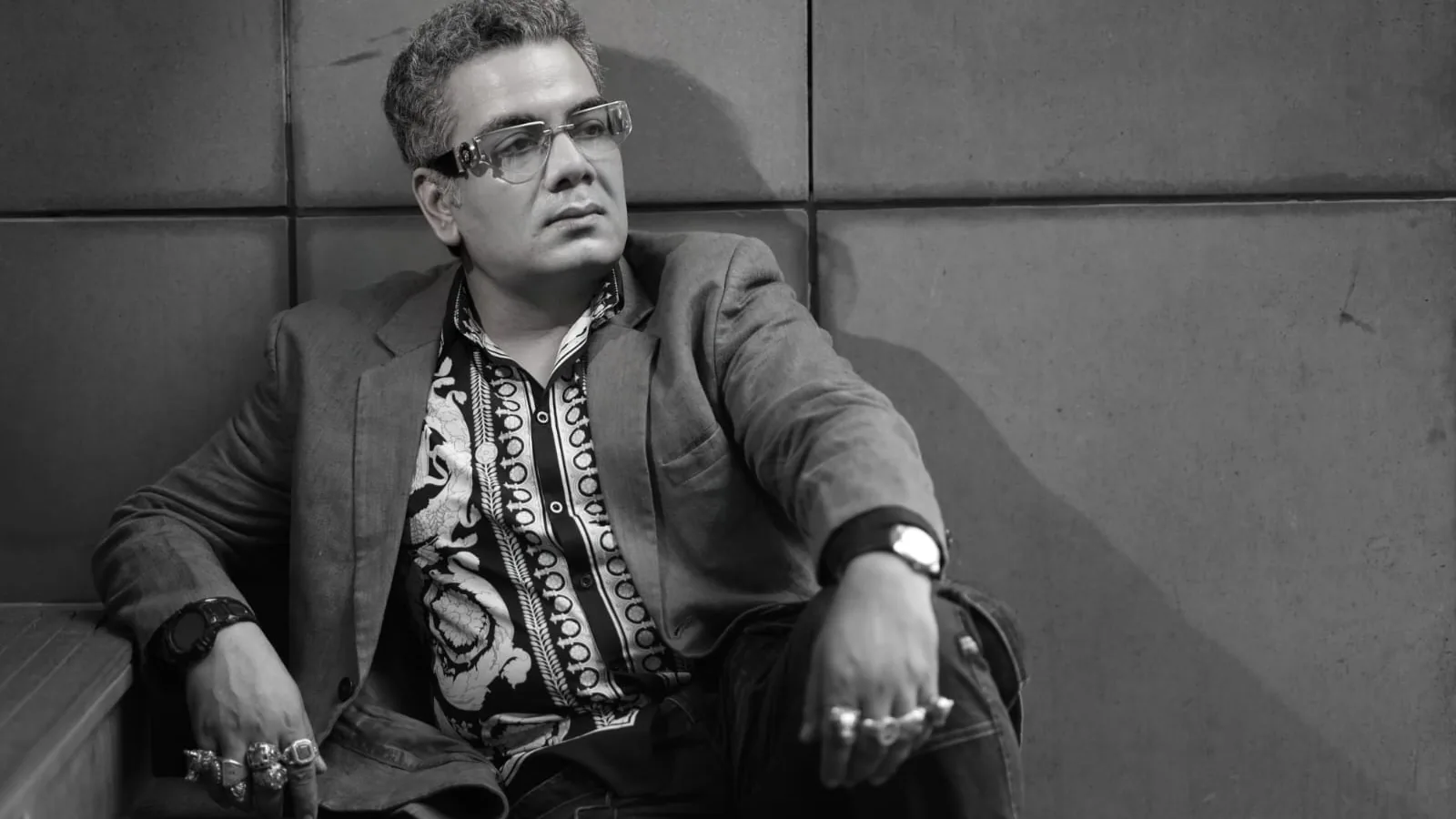 Sudeep Ranjan Sarkar seated on stone steps, in black and white
